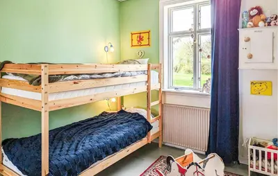 a bedroom with two bunk beds and a window at 6 Bedroom Amazing Home In Roslev in Roslev