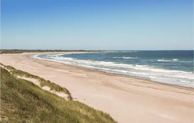 a sandy beach with the ocean in the background at 2 Bedroom Nice Home In Hanstholm in Hanstholm