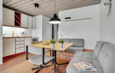a kitchen and living room with a table and a couch at Gorgeous Apartment In Brovst With Wifi in Brovst