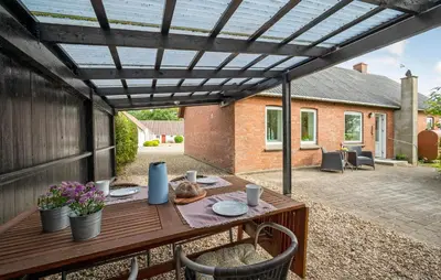 a patio with a wooden table under a pergola at 2 Bedroom Gorgeous Home In Roslev in Roslev