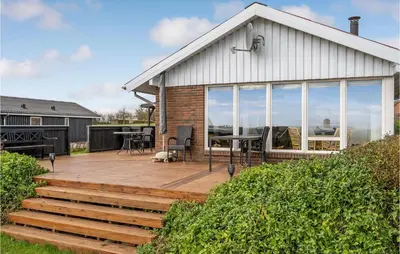 a house with a deck with a table and chairs at Cozy Home In Hurup Thy With Wifi in Doverodde