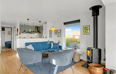 a living room with a blue couch and a stove at Cozy Home In Hurup Thy With Wifi in Doverodde