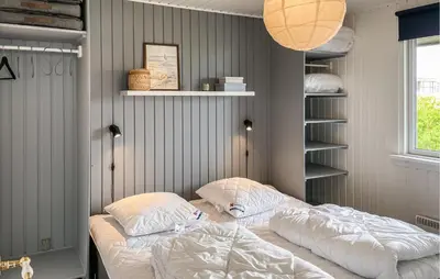 a bedroom with two beds and a book shelf at Cozy Home In Hurup Thy With Wifi in Doverodde