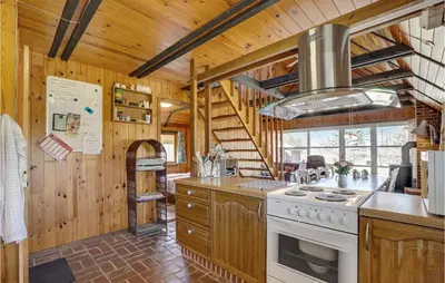 a kitchen with a stove and a staircase in a cabin at 4 Bedroom Pet Friendly Home In Løgstør in Løgstør