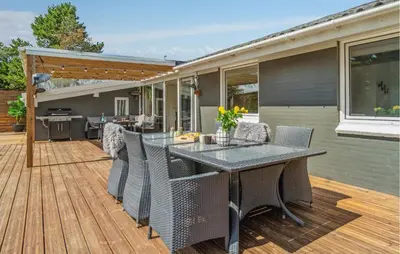 a patio with a table and chairs on a deck at Lovely Home In Thisted With Sauna in Thisted