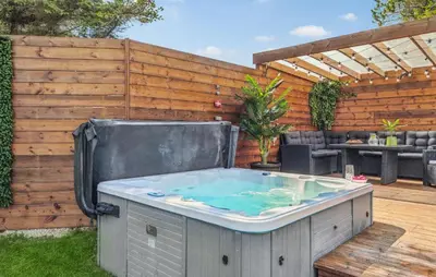 a hot tub in a backyard with a wooden fence at Lovely Home In Thisted With Sauna in Thisted