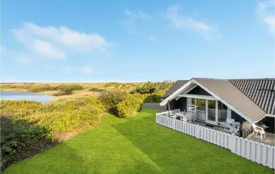 a house with a white fence and a lawn at Lovely Home In Vestervig With Wifi in Vestervig