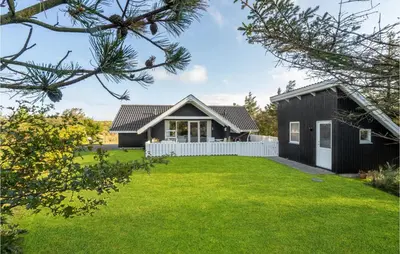 a black house with a white fence and a yard at Lovely Home In Vestervig With Wifi in Vestervig