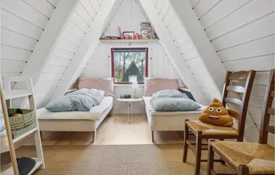 a attic room with two beds and a table at Amazing Home In Farsø With Wifi in Farsø