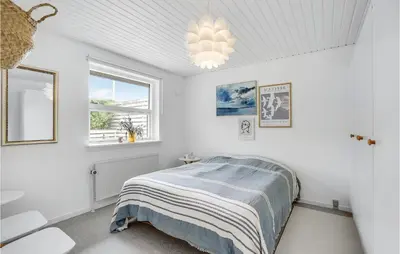 a white bedroom with a bed and a chandelier at Gorgeous Home In Thisted in Torsted