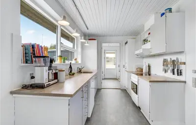 a kitchen with white cabinets and a large window at Gorgeous Home In Thisted in Torsted