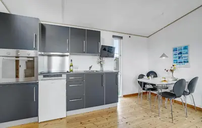 a kitchen with gray cabinets and a table with chairs at Gorgeous Home In Vestervig With Kitchen in Vestervig