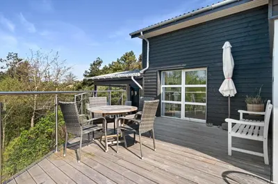a deck with a table and chairs and an umbrella at Beautiful Home In Blokhus With 1 Bedrooms in Blokhus
