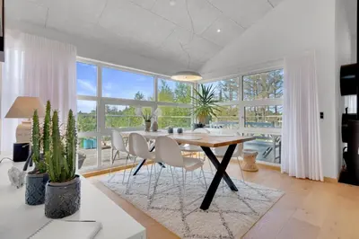 a dining room with a table and chairs and a large window at Beautiful Home In Blokhus With 1 Bedrooms in Blokhus