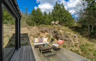a patio with two chairs and a table on a deck at 3 Bedroom Cozy Home In Blokhus in Blokhus