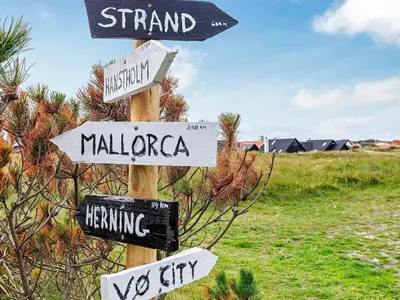 a wooden pole with street signs on it at 6 person holiday home in Thisted-By Traum in Torsted