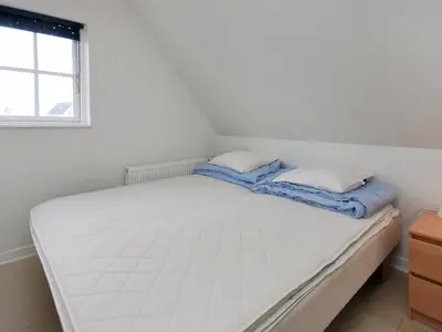 a white bed with two pillows on top of it at Holiday Home Alita - 1-2km from the sea by Interhome in Blokhus