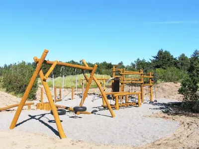 a wooden playground in the sand on a beach at Holiday Home Alita - 1-2km from the sea by Interhome in Blokhus