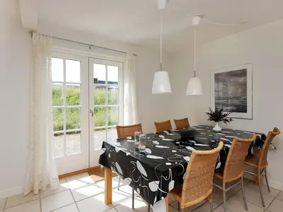 a dining room with a black and white table and chairs at Holiday Home Alita - 1-2km from the sea by Interhome in Blokhus