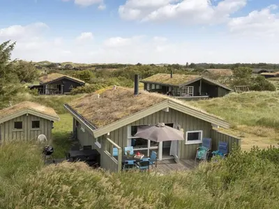 a house with a grass roof with a deck at Holiday Home Syni - 500m from the sea by Interhome in Pandrup