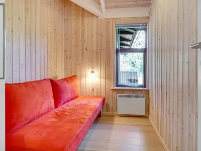 a red couch in a room with a window at Holiday Home Kali - 900m to the fjord by Interhome in Løgstør