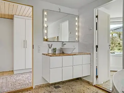 a bathroom with a sink and a mirror at Holiday Home Ejvind - 100m from the sea by Interhome in Saltum