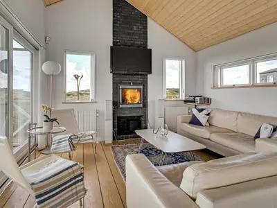 a living room with a couch and a fireplace at Holiday Home Ejvind - 100m from the sea by Interhome in Saltum