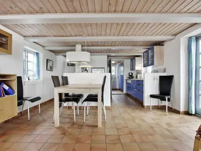 a kitchen and dining room with a table and chairs at Holiday Home Pauliina - 10m to the fjord by Interhome in Roslev
