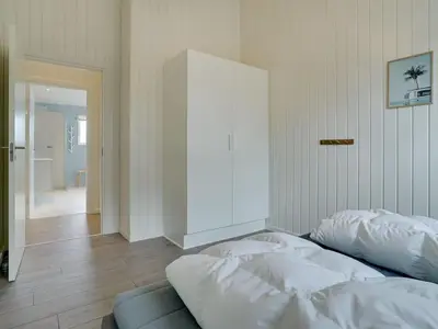 a bedroom with a bed and a white cabinet at Holiday Home Grimar - 600m from the sea by Interhome in Torsted
