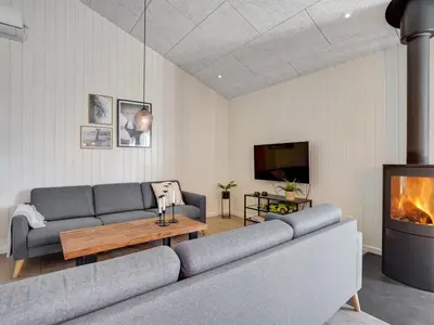 a living room with a couch and a fireplace at Holiday Home Grimar - 600m from the sea by Interhome in Torsted