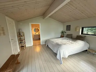 a bedroom with a bed and a wooden floor at Holiday Home Glenda - 3km from the sea by Interhome in Saltum