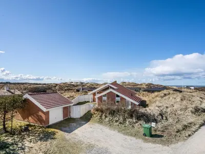a house on a hill with the ocean in the background at Holiday Home Ritha - 350m from the sea by Interhome in Saltum