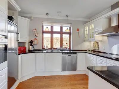 a kitchen with white cabinets and a window at Holiday Home Iarund - 500m to the fjord by Interhome in Løgstør
