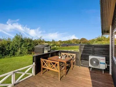 a wooden deck with a table and chairs on it at Holiday Home Awer - 300m to the fjord by Interhome in Struer