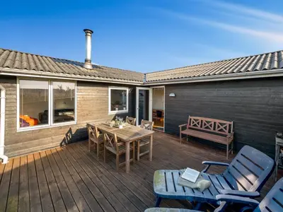 a wooden deck with a table and chairs on it at Holiday Home Awer - 300m to the fjord by Interhome in Struer
