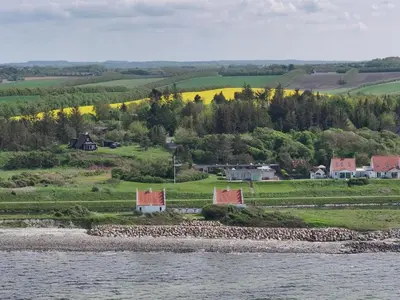 an island in the water with houses and trees at Holiday Home Aranja - 300m to the fjord by Interhome in Løgstør