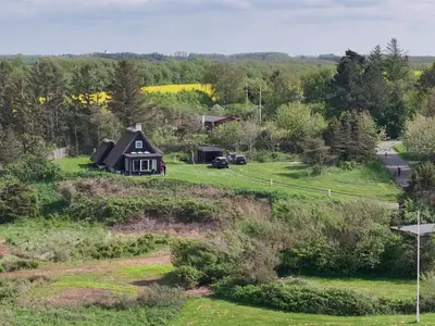 a small house on a grassy hill with a field at Holiday Home Aranja - 300m to the fjord by Interhome in Løgstør