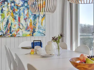 a dining room with a white table with a bowl of fruit at Holiday Home Rauli - 50m from the sea by Interhome in Saltum