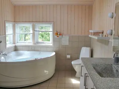 a bathroom with a tub and a toilet and a sink at Holiday Home Annick - 300m from the sea by Interhome in Fjerritslev