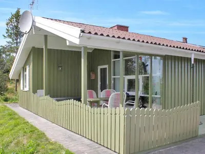 a green house with a white roof and a fence at Holiday Home Annick - 300m from the sea by Interhome in Fjerritslev
