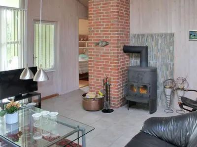 a living room with a fireplace and a stove at Holiday Home Annick - 300m from the sea by Interhome in Fjerritslev