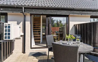 a patio with a table and chairs on a balcony at Awesome Apartment In Blokhus With Wifi in Blokhus