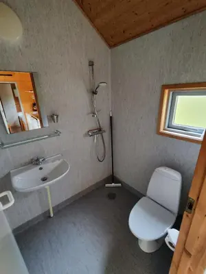 a bathroom with a toilet and a sink at Tranum Klit Camping og Hytteudlejning in Brovst