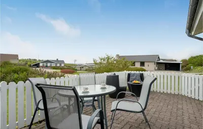 a patio with a table and chairs and a fence at 2 Bedroom Cozy Home In Lemvig in Lemvig