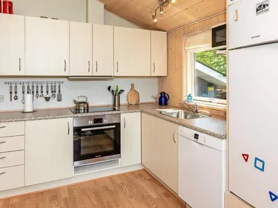 a kitchen with white cabinets and a sink and a refrigerator at 6 person holiday home in Løgstør-By Traum in Løgstør