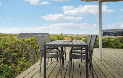 a black table and chairs on a wooden deck at 4 Bedroom Stunning Home In Thisted in Thisted